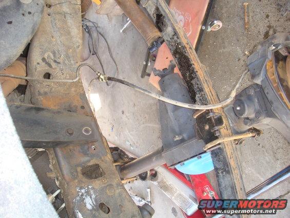 Rusty vehicle frame and suspension parts, including leaf springs and brake lines