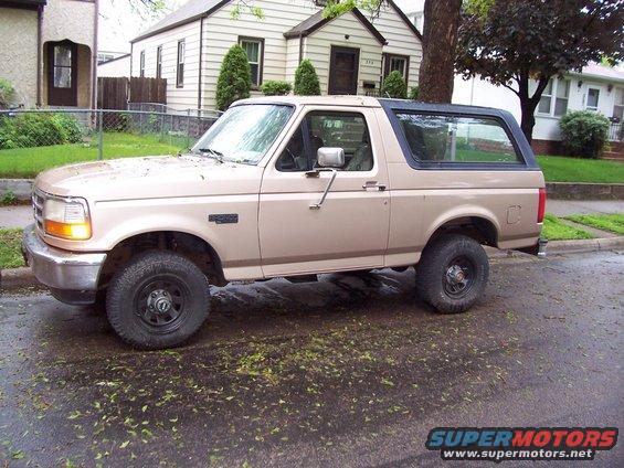 1996 Ford Bronco parked on a wet street, side view