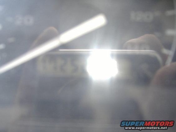 Dashboard gauge cluster with bright reflection obscuring numbers
