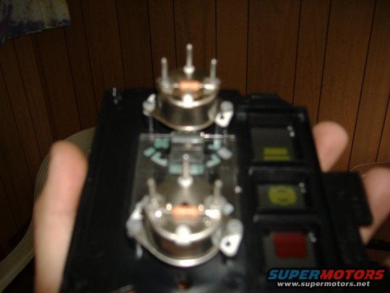 Dashboard gauge cluster part with two prominent circular components and indicator lights