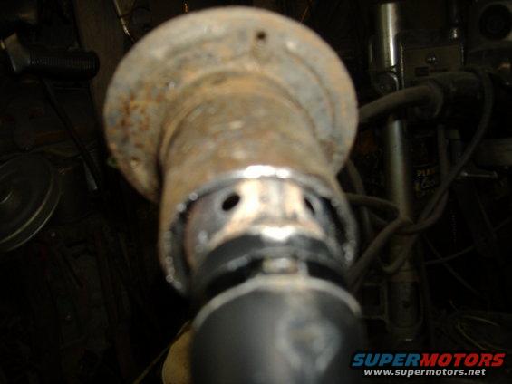 rusted metal pipe fitting with holes and a black rubber seal