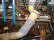 1995 Ford F-150 - Exhaust pipe with blue tape wrap, in a cluttered workshop with various tools and parts.