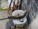 1995 Ford F-150 - A rusty exhaust pipe, a screwdriver, and a hose clamp sit on a stool outdoors.
