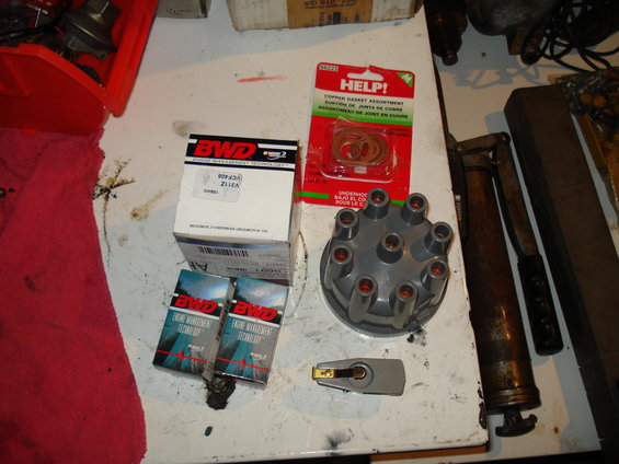 Distributor cap, rotor, and gasket set on a workbench