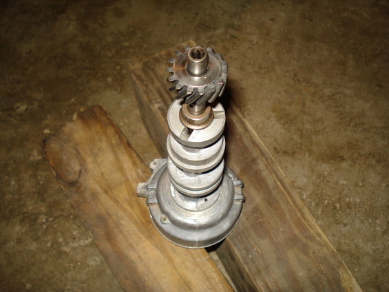 Distributor with a gear on top, resting on wood planks