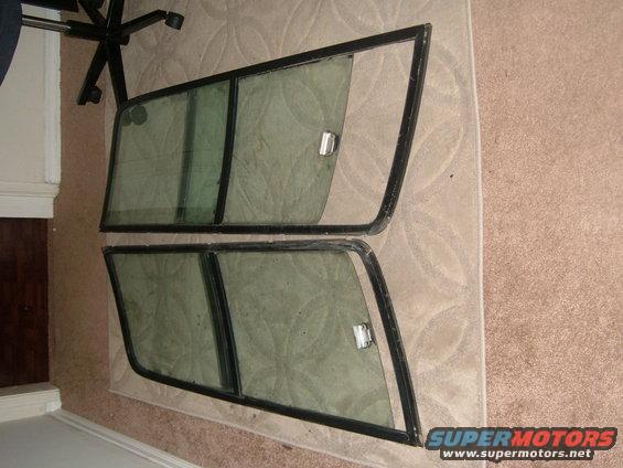 two side windows with black frames and chrome latches, laid on carpet