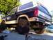 1986 Ford Bronco - This modified Ford Bronco sits high on oversized tires, suggesting off-road modifications.