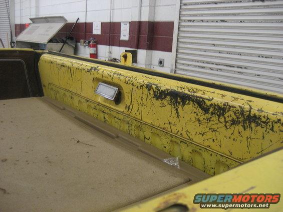 Yellow interior panel with black scuffs and a chrome handle
