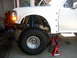 1996 Ford Bronco - Front suspension of a 1996 Ford Bronco, a large off-road tire and a prominent blue coilover shock absorber.