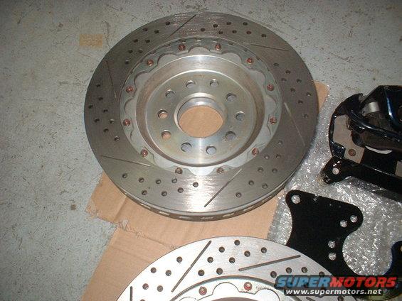 Slotted and drilled brake rotors and caliper bracket