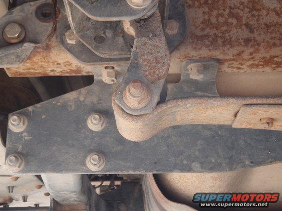 Close-up of rusted vehicle suspension parts, showing bolts and brackets