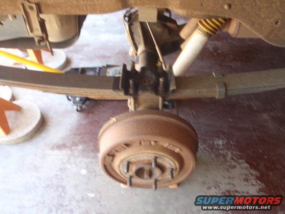 Rear leaf spring suspension with drum brake and yellow-capped shock absorber