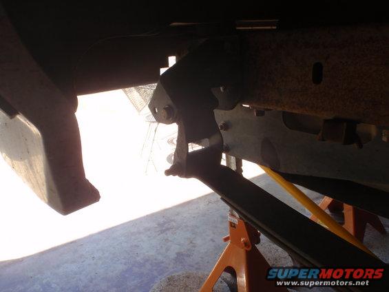 Close-up of vehicle leaf spring and bracketry mounted on orange jack stands