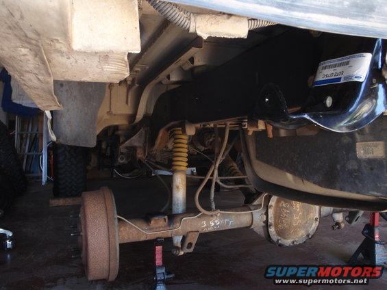 Rear axle assembly with yellow shock absorber and "1993" stamped on differential cover