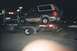 1994 Ford Bronco - A dark blue SUV, likely a 1992 Ford Bronco, is loaded onto a tow truck at night.