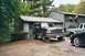 1994 Ford Bronco - A dark green Ford Bronco is parked in front of a garage, with two other vehicles visible.