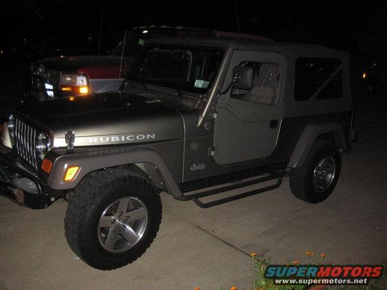 2005 Jeep Wrangler Rubicon parked next to another vehicle at night