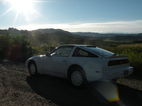 White 1989 Nissan 300ZX parked on a dirt road with hills in the background