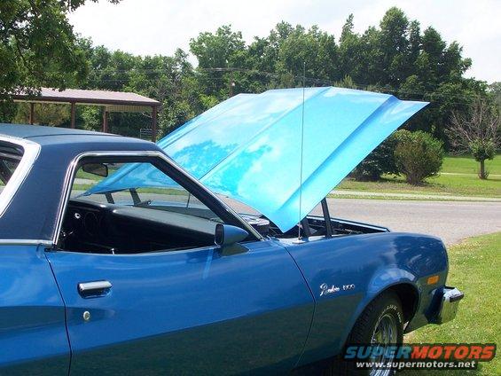 Blue pickup truck with hood open, showing a bright blue underside. Badge on fender reads 'Ranchero 500'