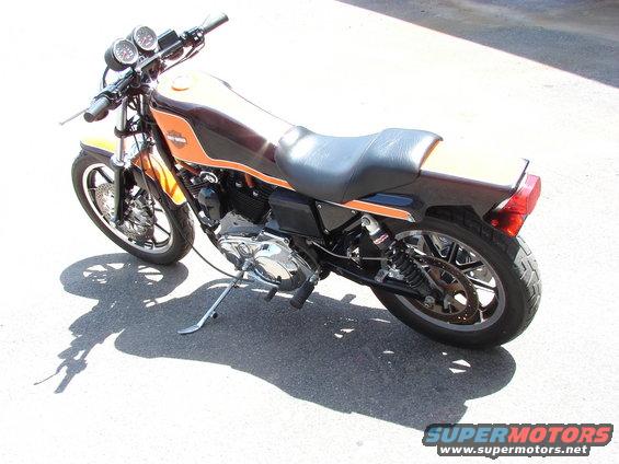 Harley-Davidson motorcycle with orange and brown paint scheme parked on asphalt