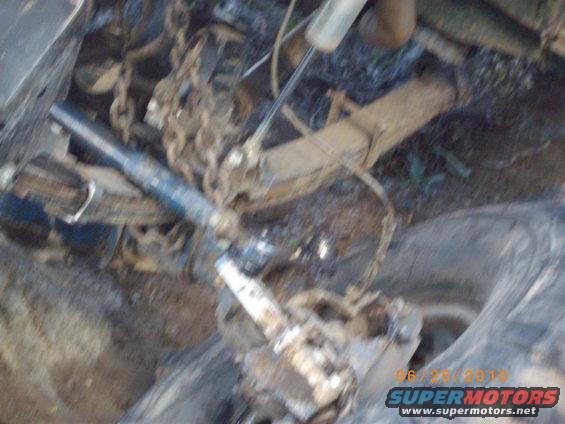 Close-up of a vehicle's suspension system with chains attached