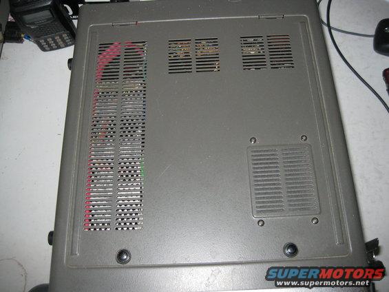 Top view of a gray electronic device with ventilation slots and visible wiring