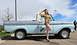 1963 Ford F-100 - A woman in a vintage-style military outfit poses next to a classic light blue and gray 1963 Ford F-100 pickup truck.