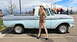 1963 Ford F-100 - A woman in a pilot costume stands beside a classic light blue Ford pickup truck at an outdoor event.