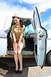 1963 Ford F-100 - A woman in a vintage military-style outfit poses next to the open door of a classic pickup truck.