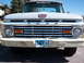 1963 Ford F-100 - Front view of a light blue 1961 Ford F-series truck with a chrome grille and a dented bumper.