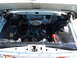 1963 Ford F-100 - The engine bay of a 1963 Ford F-100 pickup truck is shown, a prominent chrome air cleaner and various engine components.