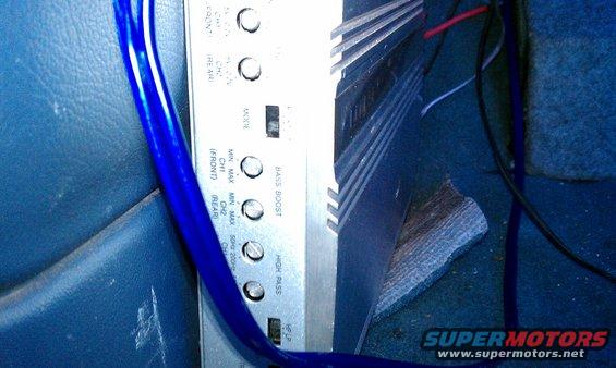 Car amplifier with blue wiring and some insulation on the floor
