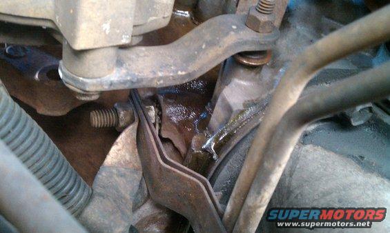 close-up of engine parts with some fluid leakage