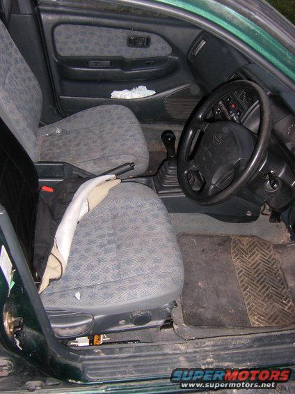 Interior of a 1998 Nissan Almera showing front seats, dashboard, and steering wheel