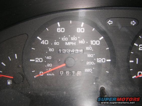 Car dashboard showing speedometer up to 140 MPH and odometer reading 133434