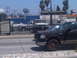 1986 Ford Bronco - A black Ford F-150 truck is parked in front of a fence with other vehicles behind it.