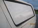 1989 Ford Bronco - Rear window of a white truck cap, showing the trim and cloudy sky.