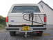 1989 Ford Bronco - Rear view of a white Ford Bronco with a spare tire carrier and a yellow license plate.