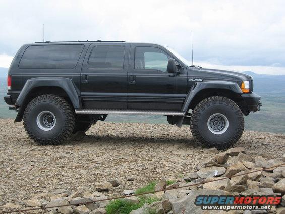 Black 2001 Ford Excursion parked on rocky terrain, side view