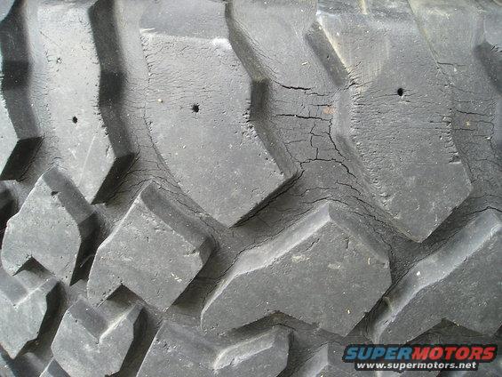 Close-up of cracked tire tread with visible holes