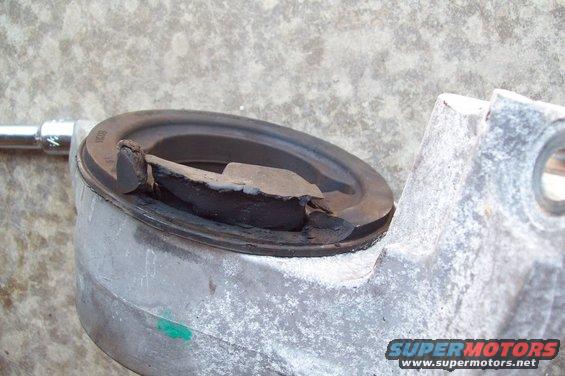 Damaged rubber engine mount on a metal bracket, close-up