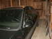 1998 Lincoln Mark VIII - The front passenger side of a black 1998 Lincoln Mark VIII is visible, parked in a rustic wooden garage.