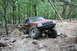 1984 Ford Bronco II - Modified Jeep Grand Cherokee tackles a challenging off-road course in a wooded area.