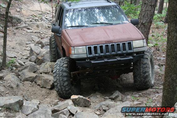 Jeep Grand Cherokee with big tires navigating a rocky trail