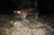 1984 Ford Bronco II - Jeep Cherokee XJ on a rocky trail at night, modified for off-roading.