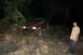 1984 Ford Bronco II - A man watches as a Jeep navigates a rocky trail in the dark.