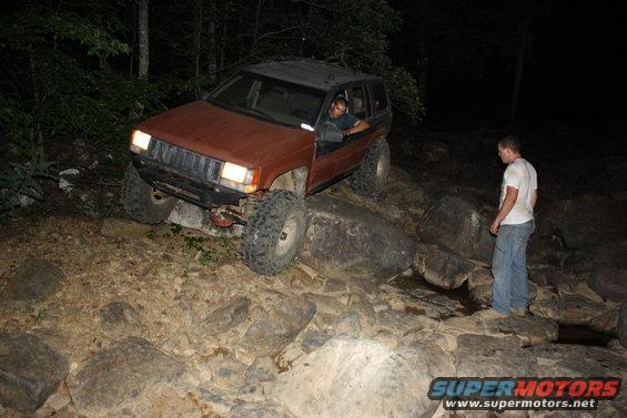 Red SUV at night, person standing beside it