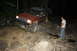 1984 Ford Bronco II - A red SUV is parked at night with a person standing next to it. The vehicle's headlights are on.
