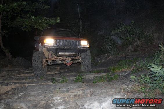 SUV with headlights on at night