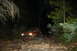 1984 Ford Bronco II - A red SUV navigates a rocky trail in the dark, illuminated by its headlights.